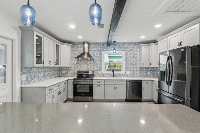 kitchen with wall chimney range hood, decorative light fixtures, beamed ceiling, and appliances with stainless steel finishes