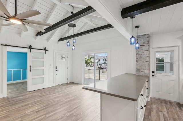 kitchen featuring ceiling fan, decorative light fixtures, white cabinets, a barn door, and light hardwood / wood-style floors