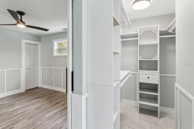 walk in closet with light hardwood / wood-style floors and ceiling fan