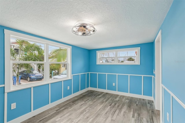 spare room featuring hardwood / wood-style floors and a textured ceiling