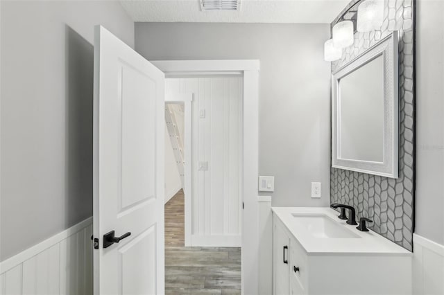 bathroom featuring hardwood / wood-style flooring, a textured ceiling, and vanity