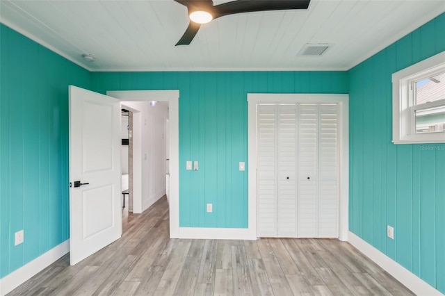 unfurnished bedroom featuring a closet, ceiling fan, crown molding, and light hardwood / wood-style floors