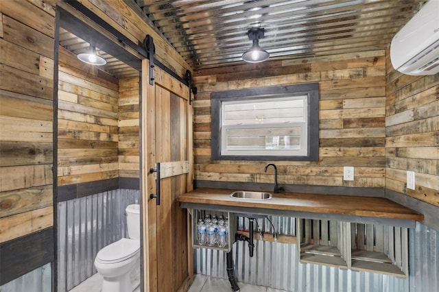 bathroom featuring sink, wood walls, toilet, and an AC wall unit