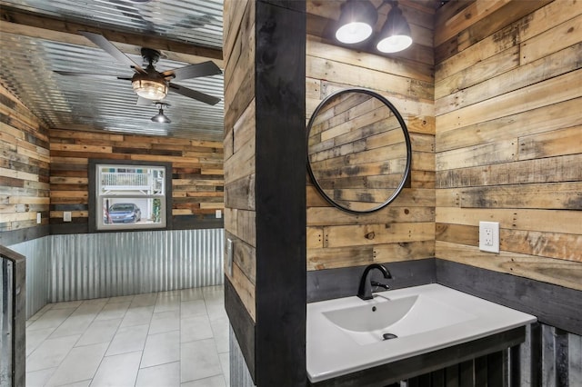 bathroom featuring sink, wood walls, tile patterned flooring, and ceiling fan