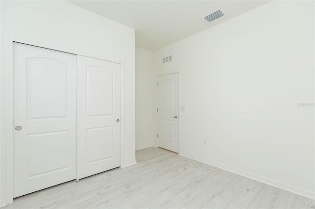 unfurnished bedroom with a closet and light hardwood / wood-style flooring