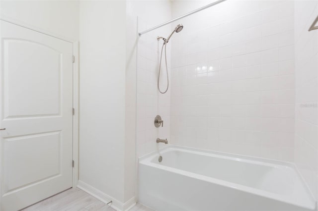 bathroom with hardwood / wood-style floors and tiled shower / bath combo