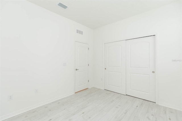 unfurnished bedroom with a closet and light wood-type flooring