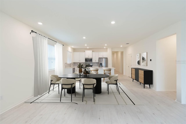 dining room with sink and light hardwood / wood-style flooring