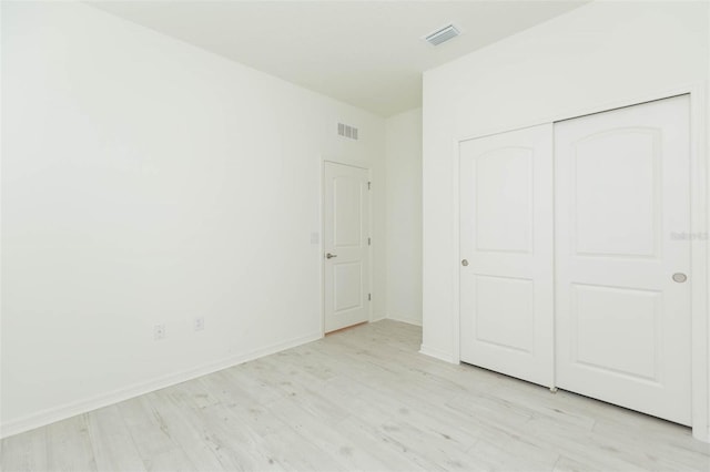 unfurnished bedroom with light hardwood / wood-style floors and a closet