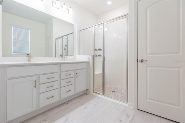 bathroom with an enclosed shower, vanity, and hardwood / wood-style flooring