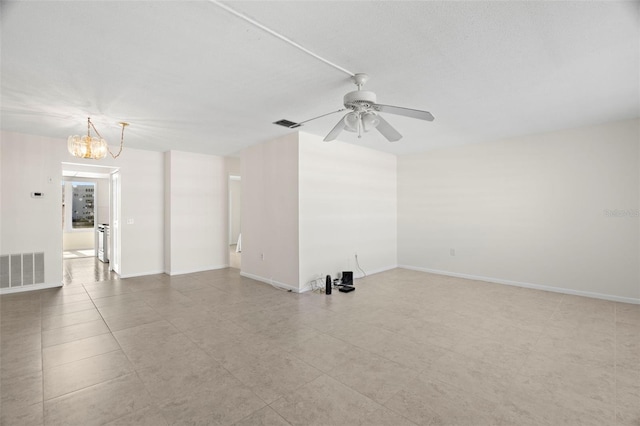 spare room with ceiling fan with notable chandelier