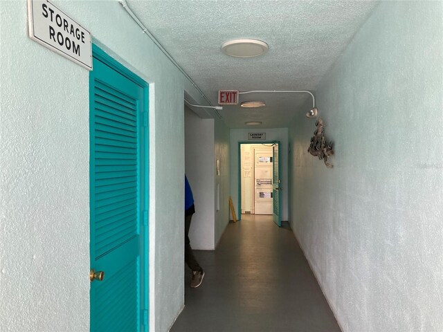 corridor with concrete flooring and a textured ceiling