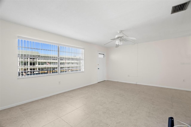 empty room featuring baseboards, visible vents, and ceiling fan
