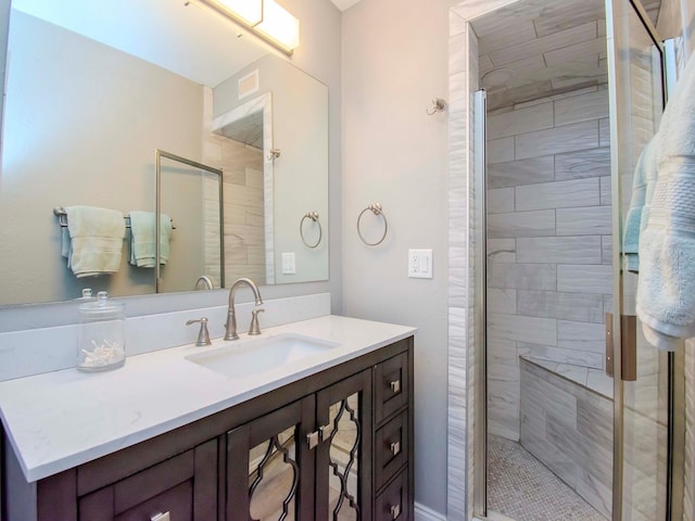 bathroom featuring a shower with shower door and vanity