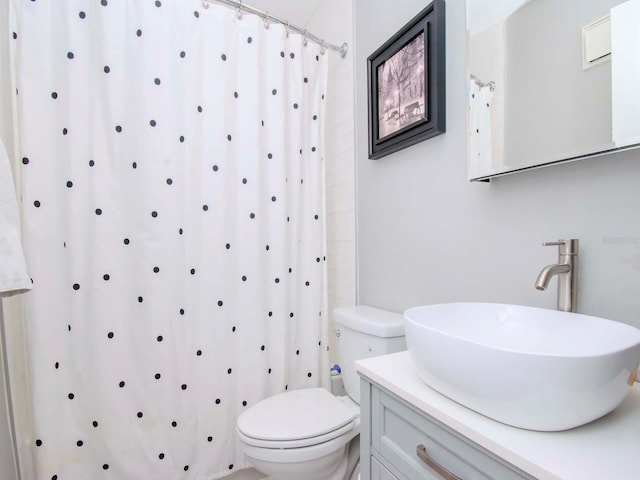 bathroom featuring toilet, a shower with shower curtain, and vanity