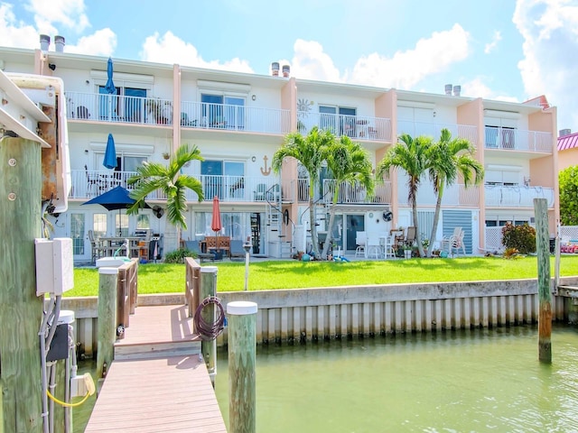 view of dock featuring a water view and a lawn