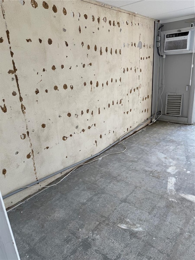 unfurnished room featuring concrete floors and a wall mounted AC