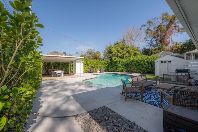 view of swimming pool with a grill, a storage shed, an outdoor living space, and a patio area