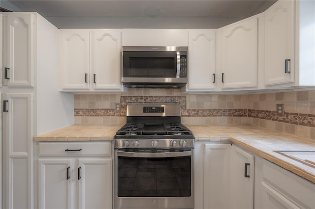 kitchen featuring white cabinetry, backsplash, and appliances with stainless steel finishes