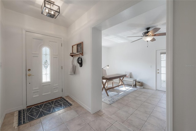 foyer with ceiling fan, a wealth of natural light, and light tile patterned floors