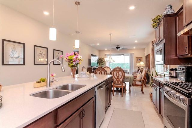 kitchen with stainless steel appliances, pendant lighting, light countertops, and a sink