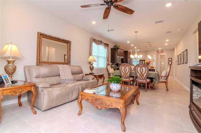 living room with light tile patterned floors, recessed lighting, visible vents, baseboards, and ceiling fan with notable chandelier