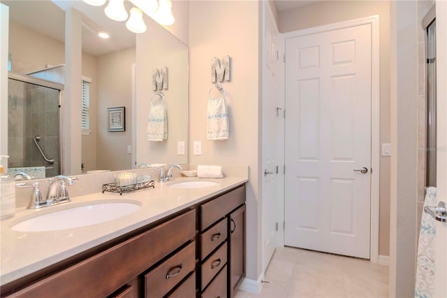 full bath featuring tiled shower, a sink, baseboards, and double vanity