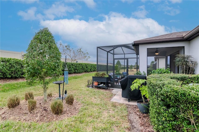 view of yard featuring a patio, a lanai, and a ceiling fan