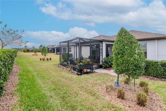 back of house with a lanai and a lawn