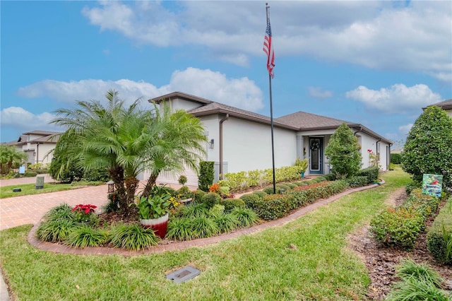 view of side of home featuring a garage, decorative driveway, a lawn, and stucco siding