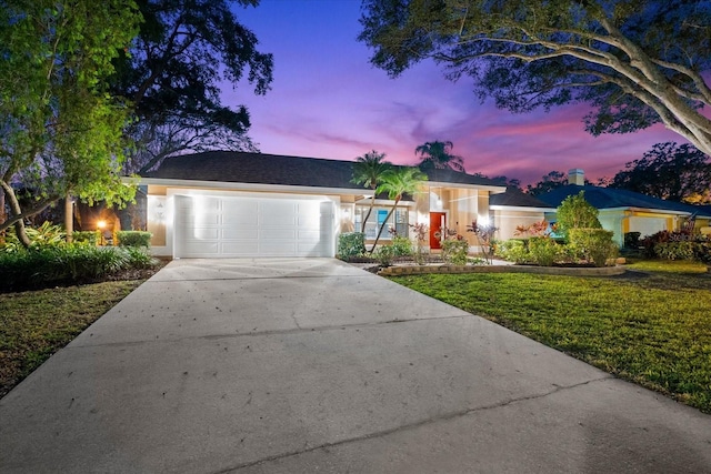 ranch-style home with a lawn and a garage