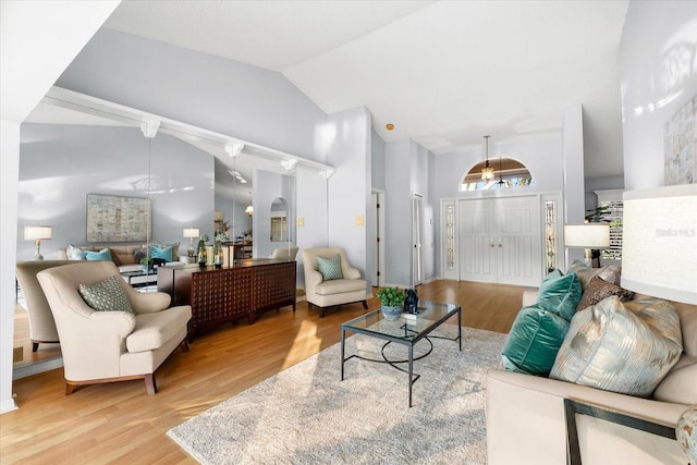 living area with high vaulted ceiling and wood finished floors