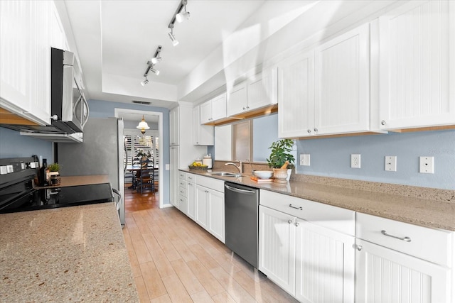 kitchen featuring appliances with stainless steel finishes, light wood-type flooring, and white cabinets