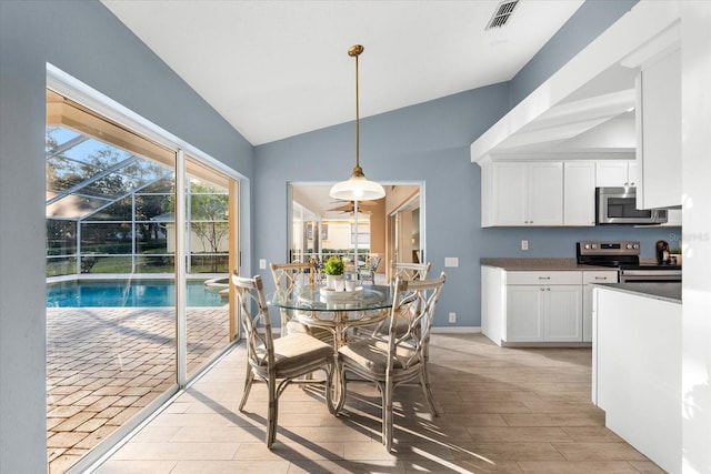 dining space featuring light wood-type flooring, lofted ceiling, visible vents, and baseboards