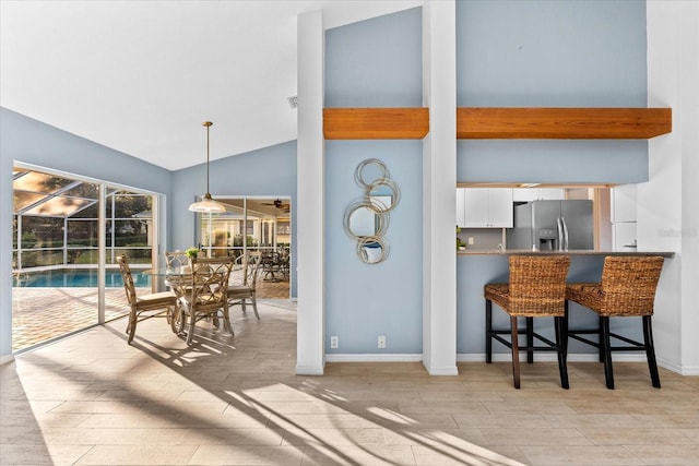 kitchen featuring wood finished floors, a sunroom, baseboards, white cabinetry, and stainless steel fridge with ice dispenser