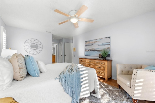 bedroom with ceiling fan, wood finished floors, and visible vents