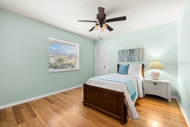 bedroom with a closet, baseboards, and light wood finished floors