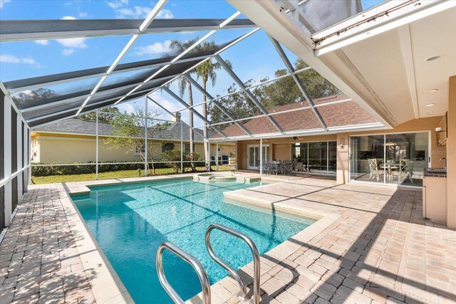 view of pool featuring a patio, a pool with connected hot tub, a lanai, and a ceiling fan