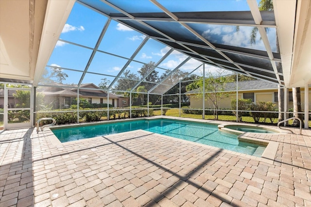 view of pool with glass enclosure, a patio area, and a pool with connected hot tub