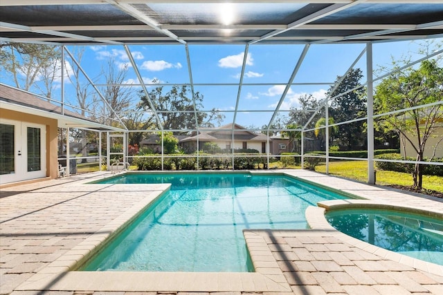 view of swimming pool with glass enclosure, a pool with connected hot tub, french doors, and a patio