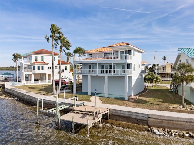 dock area with a yard, a balcony, and a water view