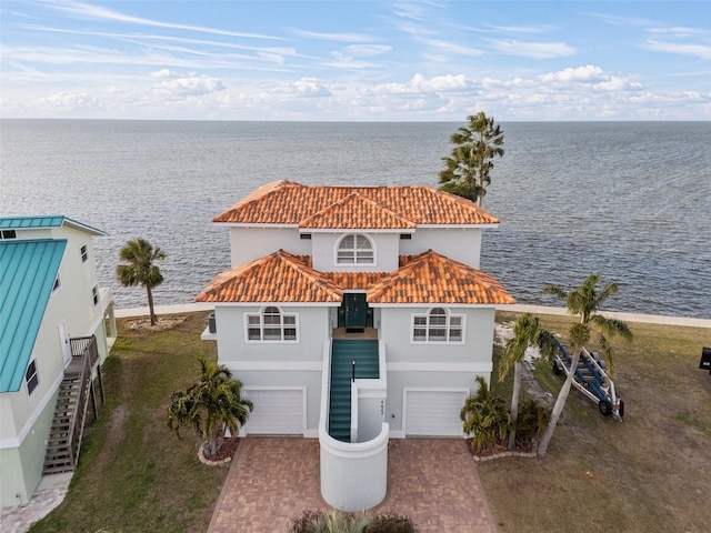 exterior space with a garage, a water view, and a front yard