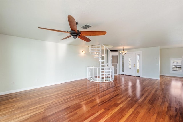 unfurnished living room featuring hardwood / wood-style flooring and ceiling fan with notable chandelier