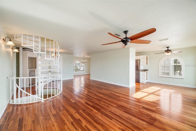 unfurnished living room featuring wood-type flooring and a chandelier