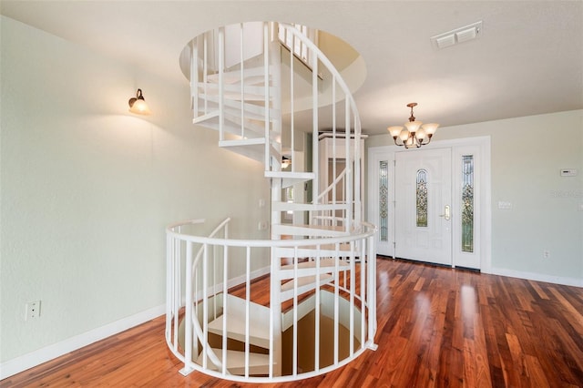 foyer entrance featuring an inviting chandelier and wood-type flooring