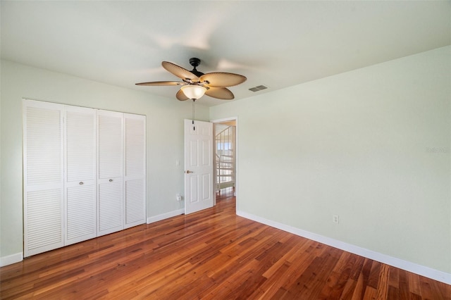 unfurnished bedroom with wood-type flooring, a closet, and ceiling fan