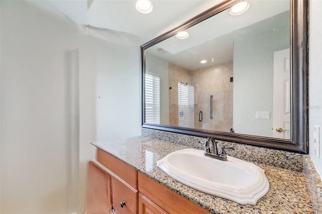 bathroom featuring vanity and a shower with door