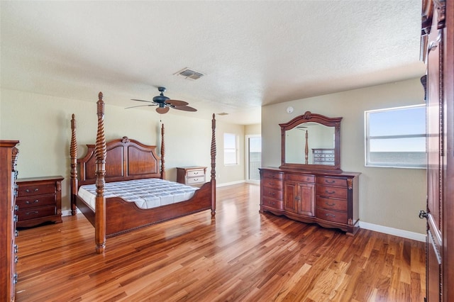 bedroom with wood-type flooring, a textured ceiling, and ceiling fan