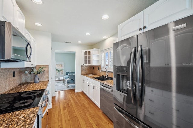 6423 Driftwood Dr, Hudson, FL 34667 - kitchen featuring stainless steel appliances, a sink, decorative backsplash, light wood-style flooring, and white cabinetry