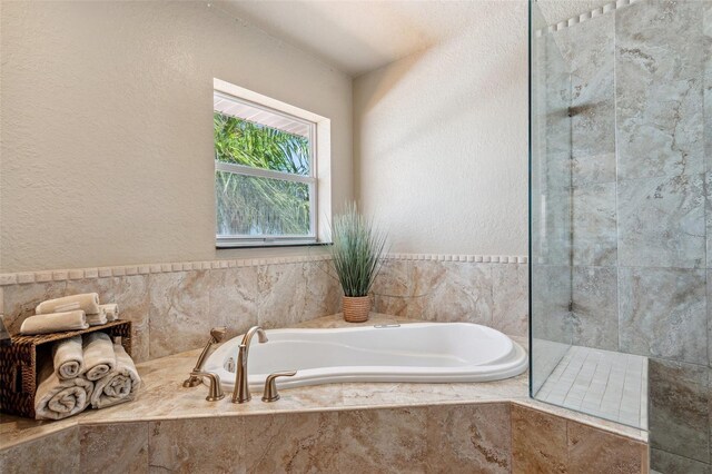 6423 Driftwood Dr, Hudson, FL 34667 - bathroom featuring a garden tub, a tile shower, and a textured wall